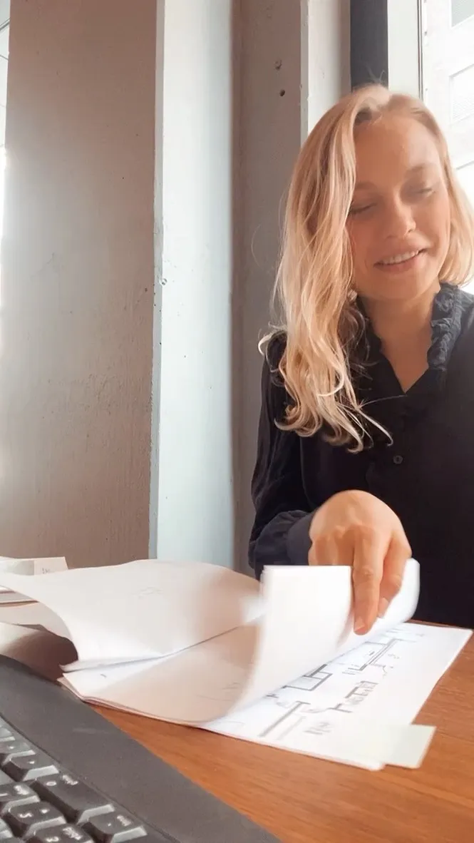 Luca Maya Bartnitzki im Gespräch an einem Tisch mit Notizen und einer Tasse